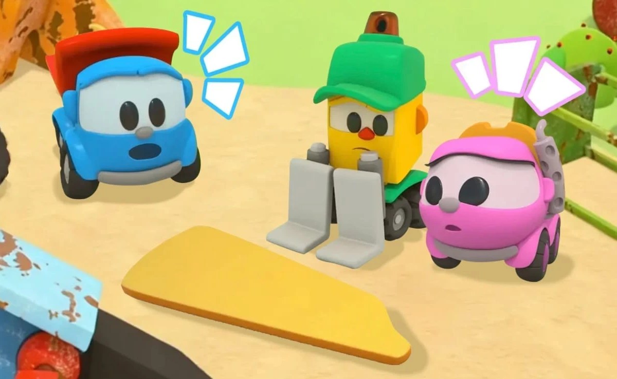 Leo the Truck, a yellow machine with a green cap and a pink truck gathered next to a yellow panel on sandy ground